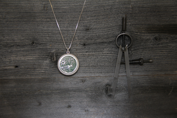 Bilde av halskjede i sølv med motiv av rein go sol.