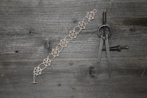 Foto av sølvarmbånd med samisk motiv.