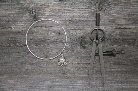 Foto av en sølvarmbånd med komsekule som pynt.