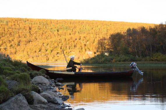 Båtmann sitter i båten for å trekker inn not med Gealli.