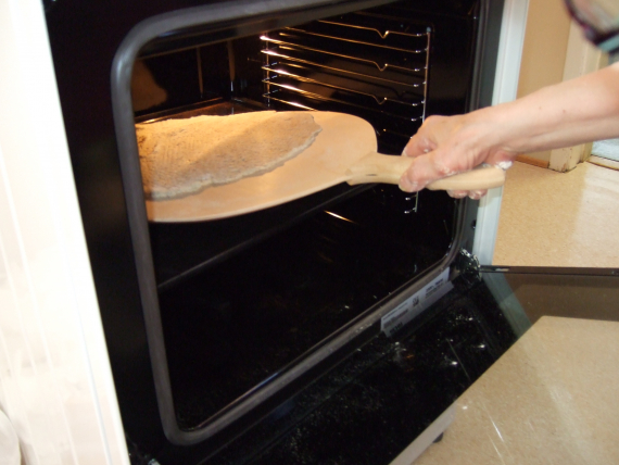 En som steker samebrød i ovnen.