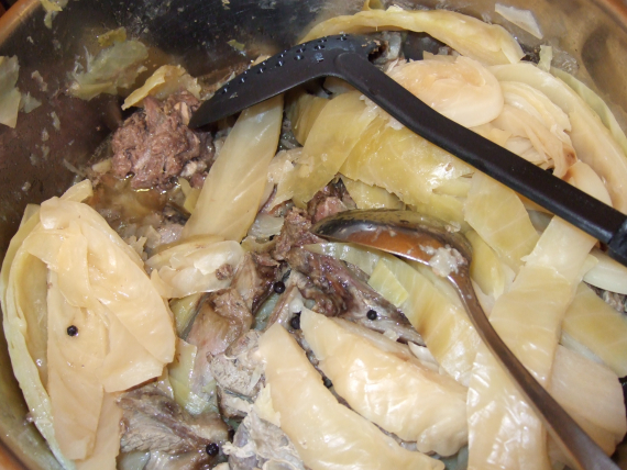 Kjøtt, kål og fløte i en gryte .