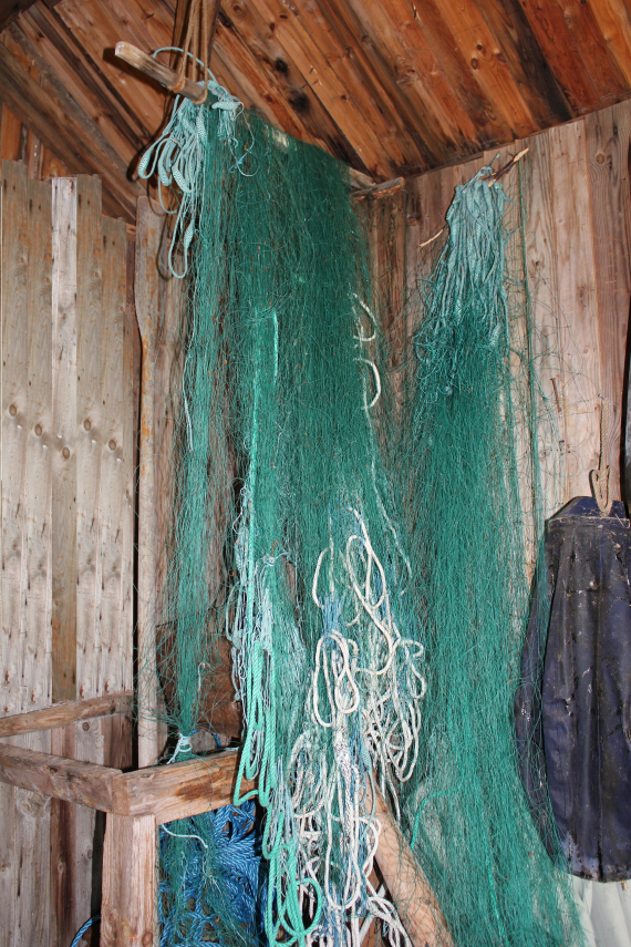 Fiskegarn som henger i et naust.