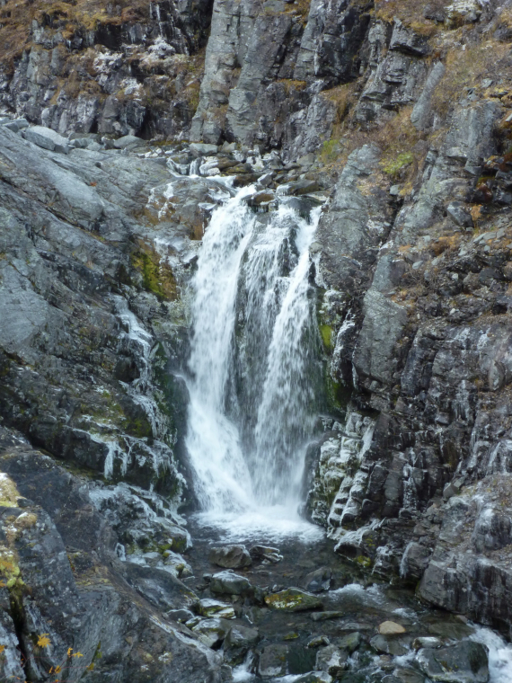 Bilde av en foss omgitt av stein.