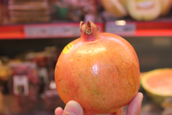 Bilde av noen som holder en granateple.