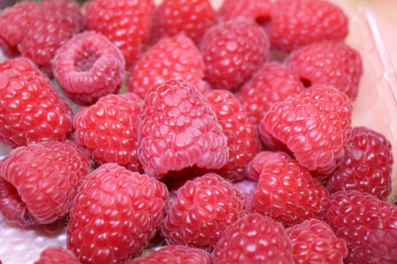 Nærbilde av bringebær i en kurv.