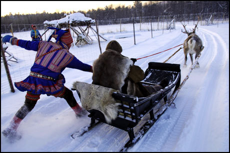 Bilde av en turist som kjører reinsdyr om vinteren.