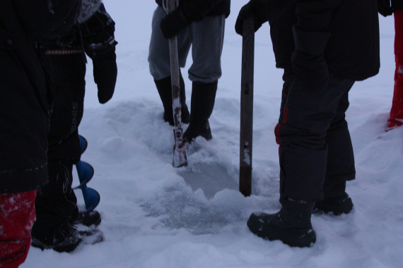 Lage hull i isen med borr og hakke.