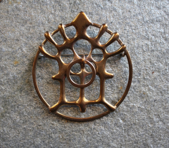 Foto av en Mariabrosje i messing.