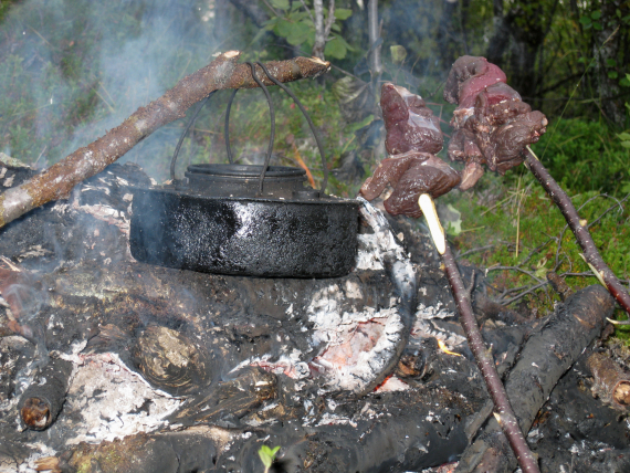 kaffekjele og kjøttstykker på spyd over bålet.