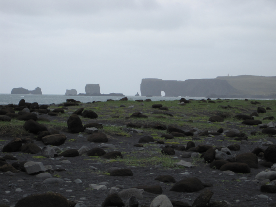 Bilde av masse stein på en strand ved kysten.