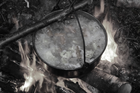 Vann som kokes i gryte over bålet.