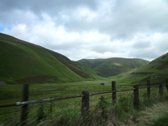 Fjellområder med grønne gress på fjellsidene.