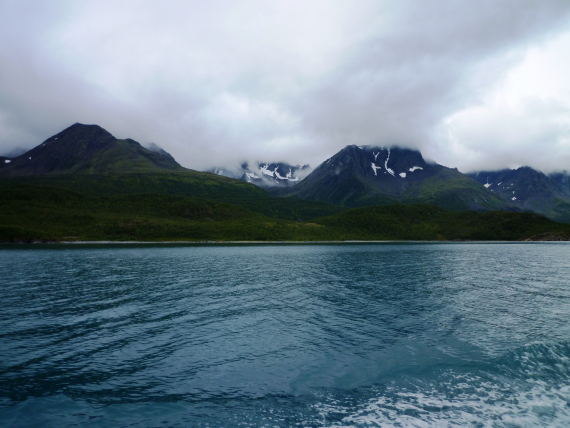 Foto av sjø og høge fjell.