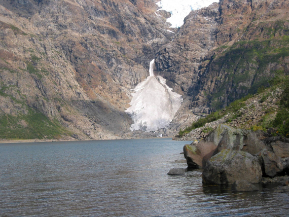 Isbre i en fjellside nært et vann.