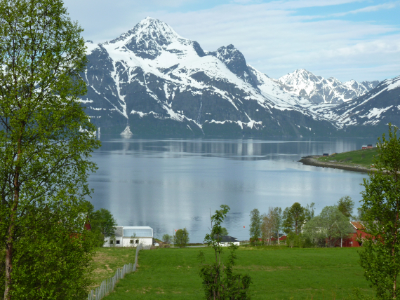Bilde av kystlandskap med snødekte fjelltopper.